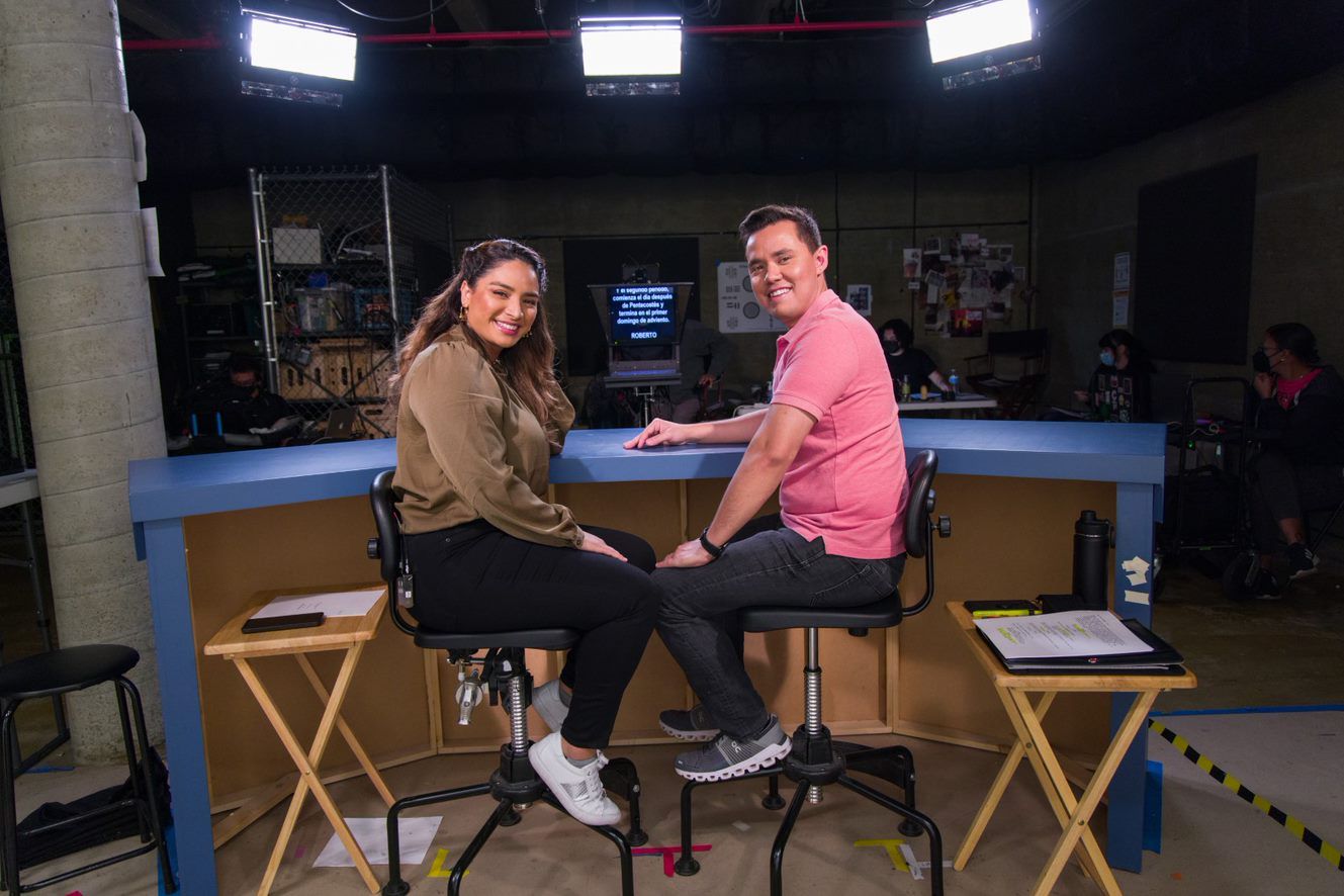 The two hosts of Lente Catolico sitting at a broadcast desk