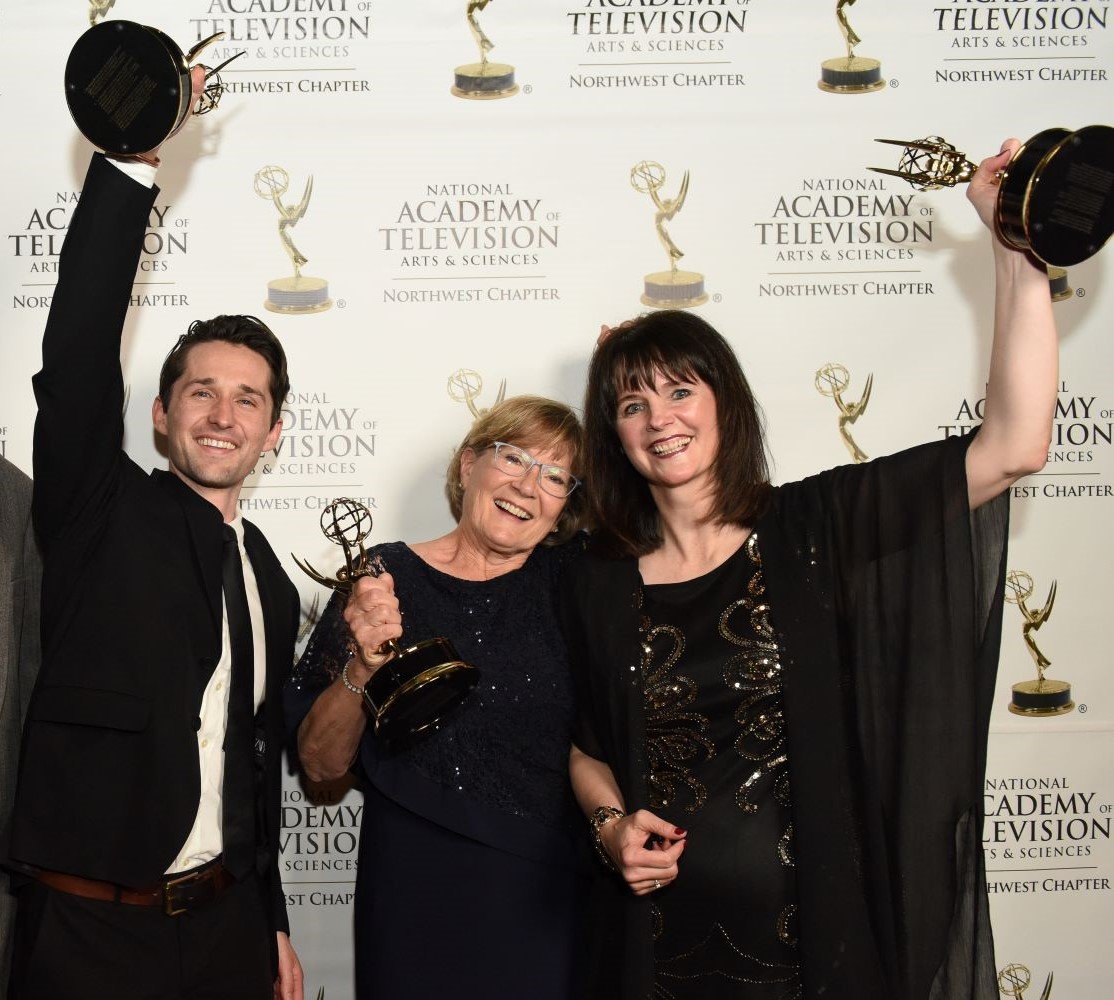 Three people holding up filmmaking awards