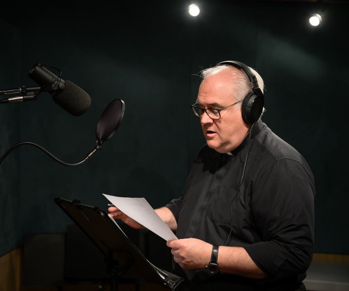 A voice actor reading into a professional microphone